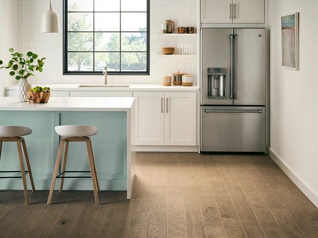 blue island table with white countertop in a kitchen with brown hardwood floor by Pat Smith’s Flooring in Louisville, KY